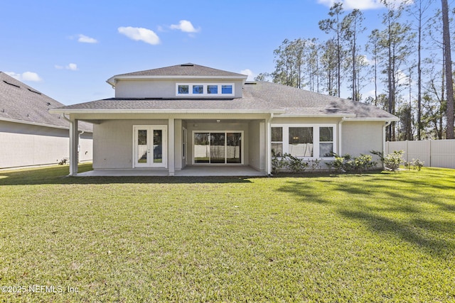 rear view of property featuring a lawn, a patio, fence, french doors, and a shingled roof