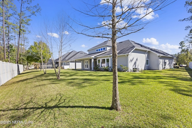 view of front facade featuring stucco siding, a front lawn, and fence