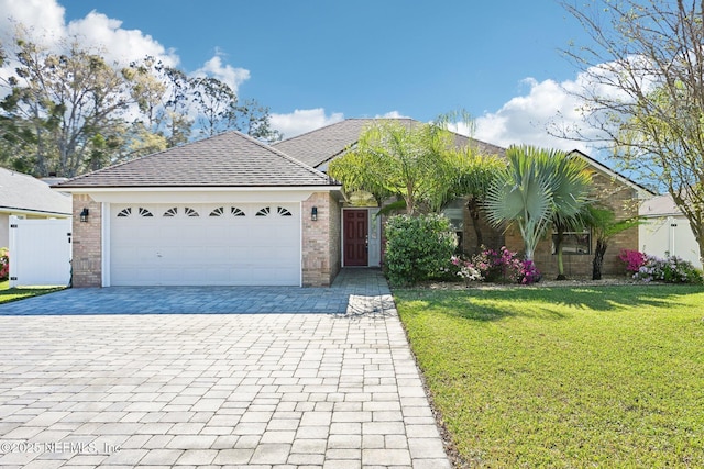 single story home with brick siding, a shingled roof, a front lawn, decorative driveway, and an attached garage