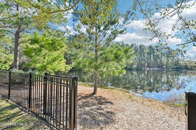 exterior space with a water view and fence