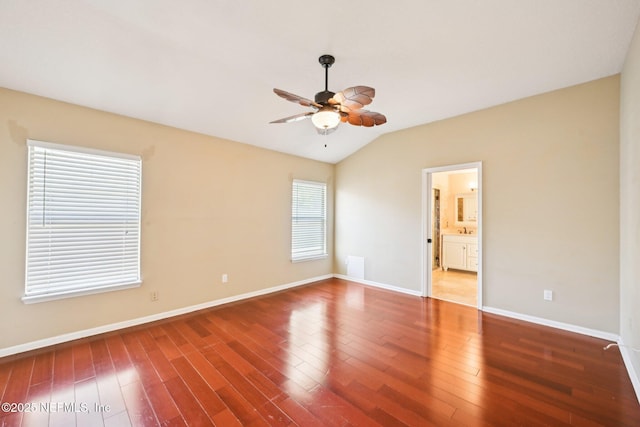 spare room featuring vaulted ceiling, baseboards, a ceiling fan, and wood finished floors