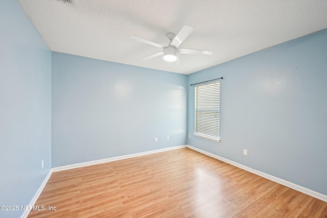 empty room with baseboards, light wood-style flooring, and a ceiling fan