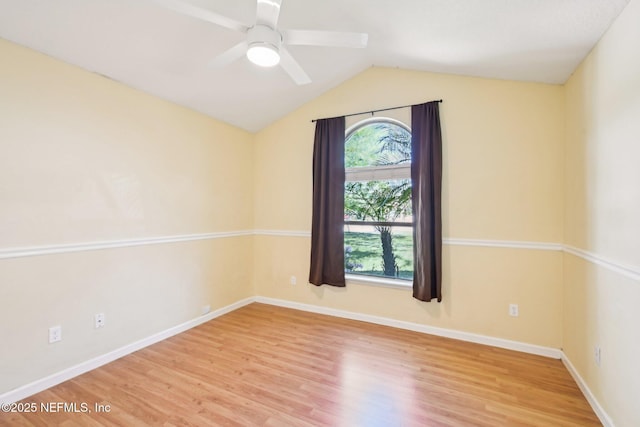 unfurnished room featuring vaulted ceiling, baseboards, a ceiling fan, and wood finished floors