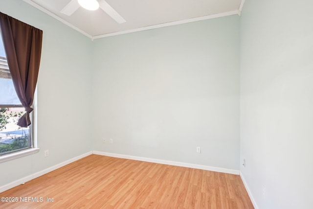 spare room featuring baseboards, ceiling fan, crown molding, and light wood finished floors