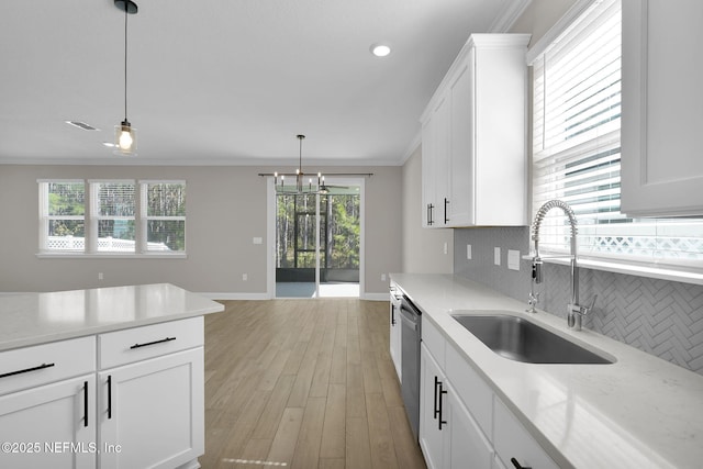 kitchen with a sink, white cabinets, dishwasher, crown molding, and tasteful backsplash