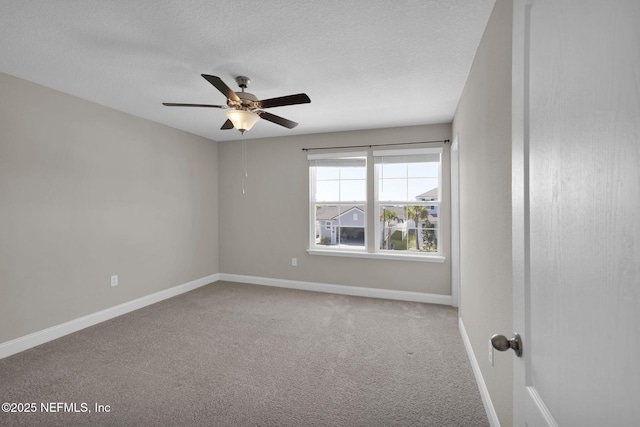 carpeted spare room featuring a textured ceiling, baseboards, and a ceiling fan