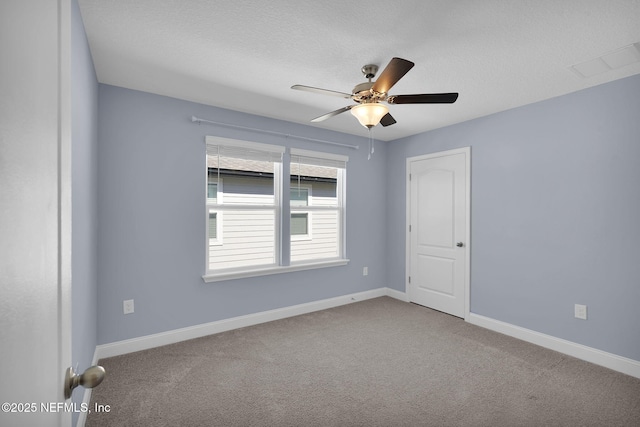 spare room featuring a ceiling fan, visible vents, carpet, baseboards, and a textured ceiling