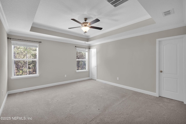 unfurnished room with a ceiling fan, a raised ceiling, crown molding, and light colored carpet