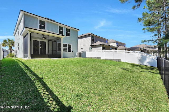 back of property featuring a lawn, a fenced backyard, a sunroom, central AC unit, and ceiling fan