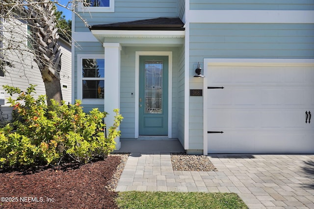 view of exterior entry featuring a shingled roof