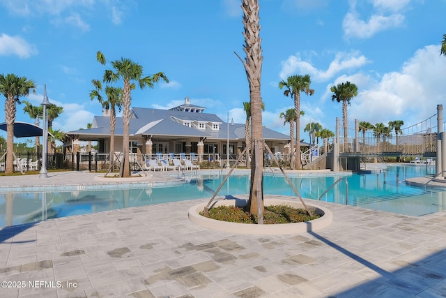 pool with a patio and fence