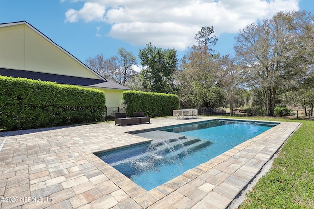 pool with a patio area and fence