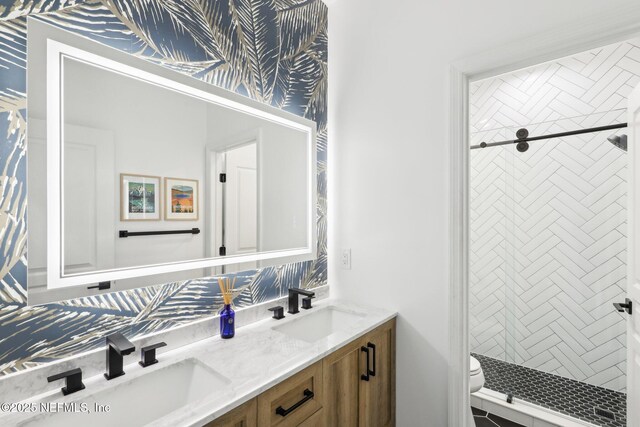 full bath featuring double vanity, a shower stall, toilet, and a sink