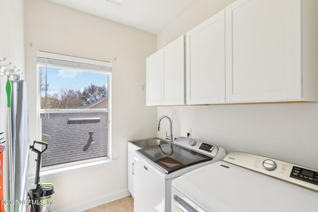 washroom with a sink, cabinet space, separate washer and dryer, light tile patterned flooring, and baseboards