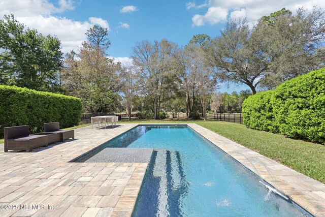 view of pool featuring a yard, a patio area, a fenced in pool, and a fenced backyard