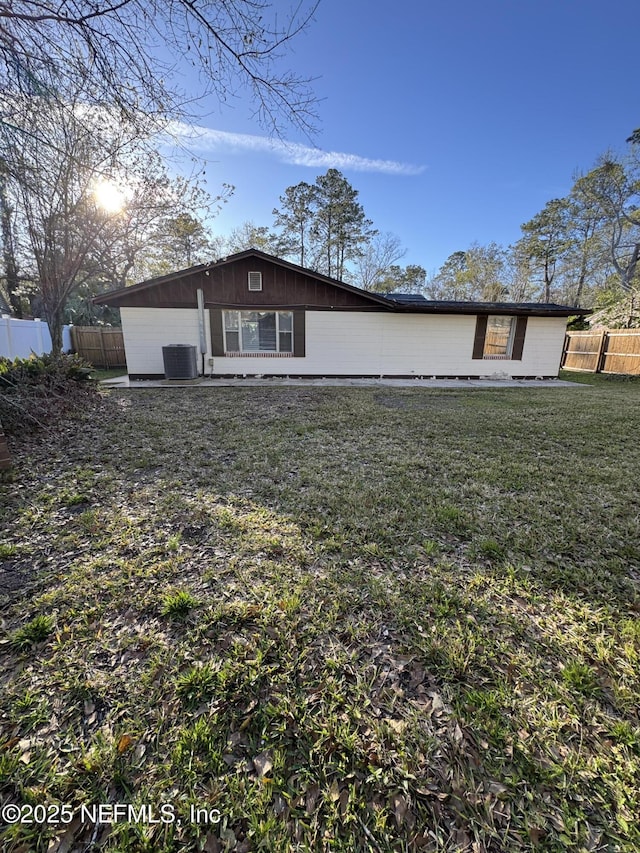 back of house featuring a lawn, fence, and central AC