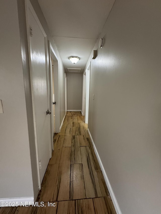 hallway with baseboards and wood finished floors