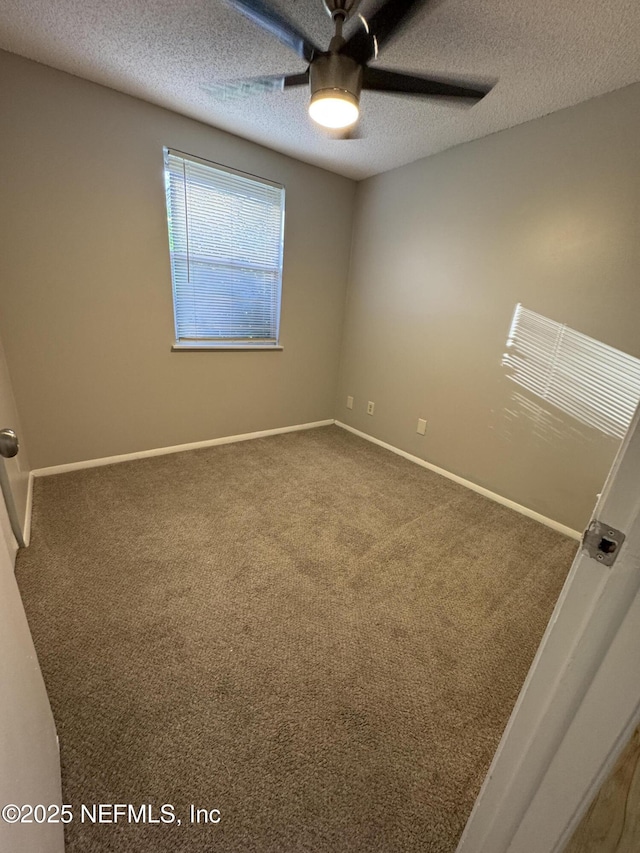 carpeted empty room featuring baseboards, a textured ceiling, and a ceiling fan