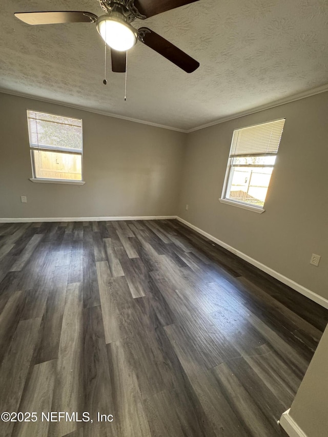 empty room with crown molding, dark wood-style floors, a wealth of natural light, and a textured ceiling