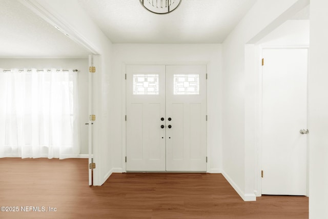 entryway with baseboards and wood finished floors