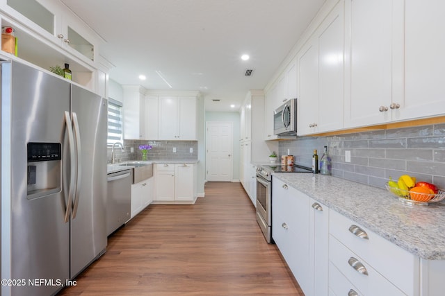 kitchen featuring white cabinetry, wood finished floors, visible vents, and appliances with stainless steel finishes