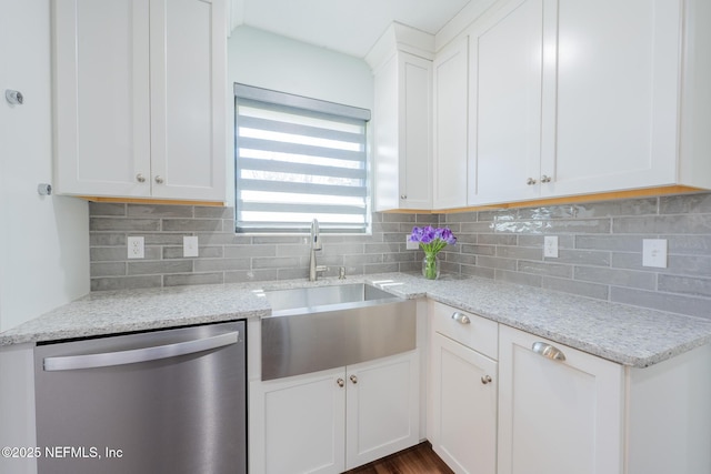 kitchen with light stone counters, white cabinetry, a sink, dishwasher, and tasteful backsplash