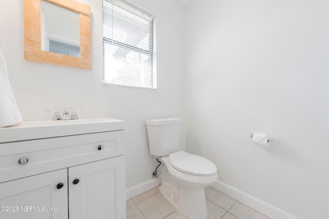 bathroom featuring tile patterned floors, baseboards, toilet, and vanity