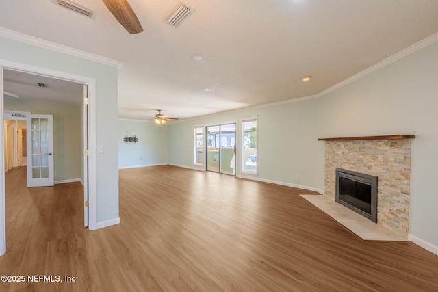 unfurnished living room with visible vents, a fireplace, light wood-type flooring, and french doors