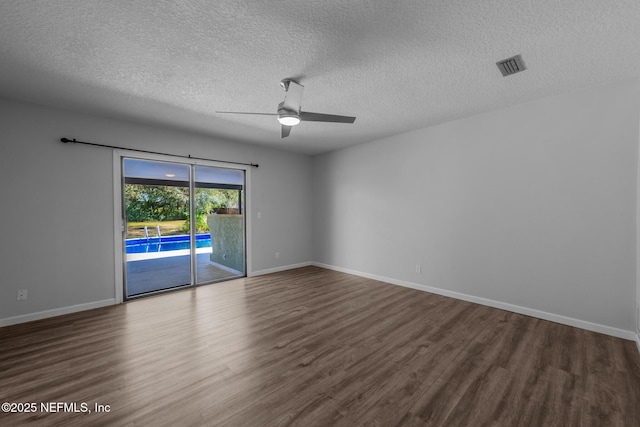 spare room featuring visible vents, baseboards, wood finished floors, and a ceiling fan