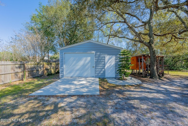 detached garage with driveway and fence