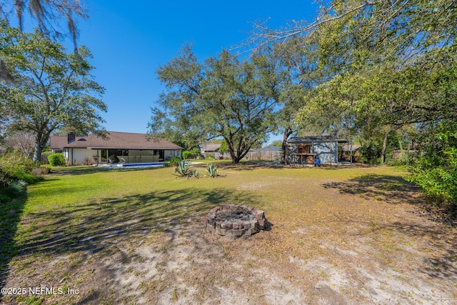 view of yard with an outdoor pool and an outdoor fire pit