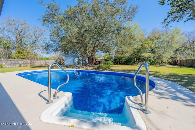 view of pool with an outbuilding, a fenced backyard, a shed, a yard, and a fenced in pool