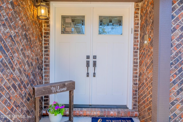 doorway to property featuring brick siding