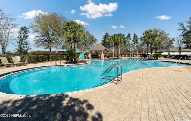 community pool with a gazebo, fence, and a patio