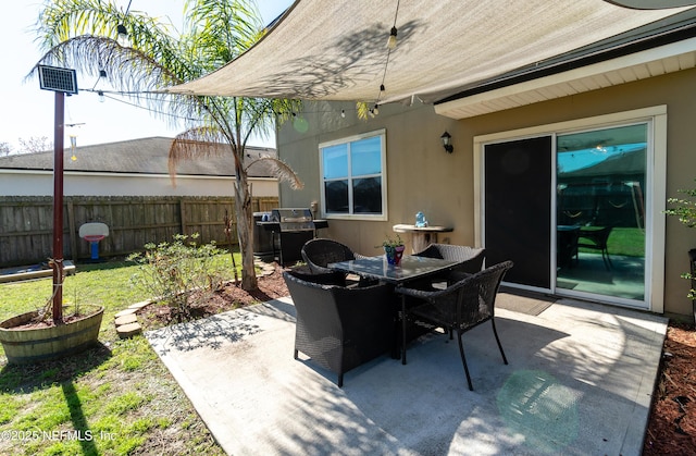 view of patio / terrace with grilling area, outdoor dining area, and fence