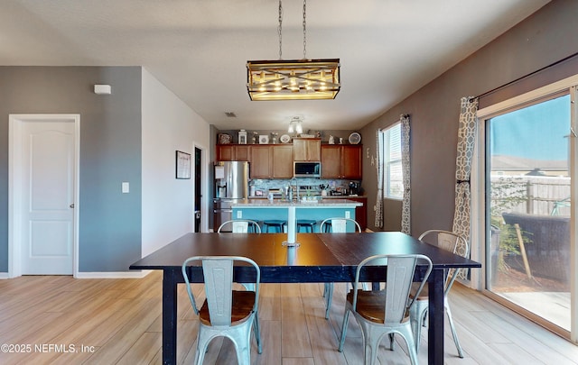 dining room featuring light wood-type flooring and baseboards