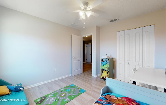 bedroom featuring visible vents, a closet, light wood finished floors, baseboards, and ceiling fan