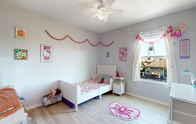 bedroom featuring ceiling fan, light wood-type flooring, and baseboards