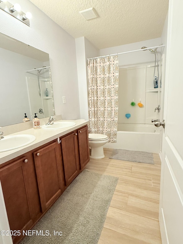 3648 Summit Oaks Dr, Green Cove Springs, FL 32043 - bathroom featuring double vanity, wood finished floors, toilet, shower / tub combo with curtain, and a textured ceiling