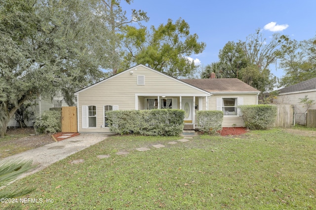 view of front of home with a gate, a chimney, a front lawn, and fence