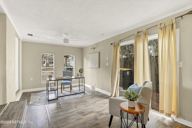 office area featuring visible vents, a textured ceiling, wood finished floors, and a ceiling fan