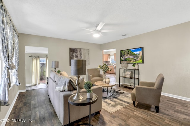 living area with visible vents, a textured ceiling, a healthy amount of sunlight, and wood finished floors