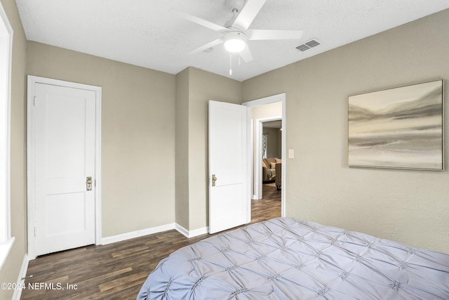 bedroom featuring visible vents, a ceiling fan, a textured ceiling, wood finished floors, and baseboards