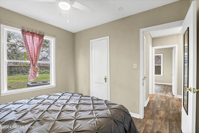 bedroom featuring a ceiling fan, dark wood-style floors, baseboards, and a textured ceiling