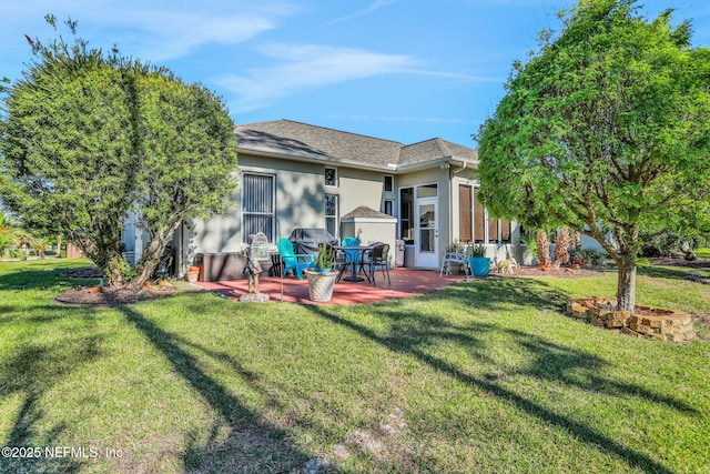 back of property featuring stucco siding, a lawn, a shingled roof, and a patio area