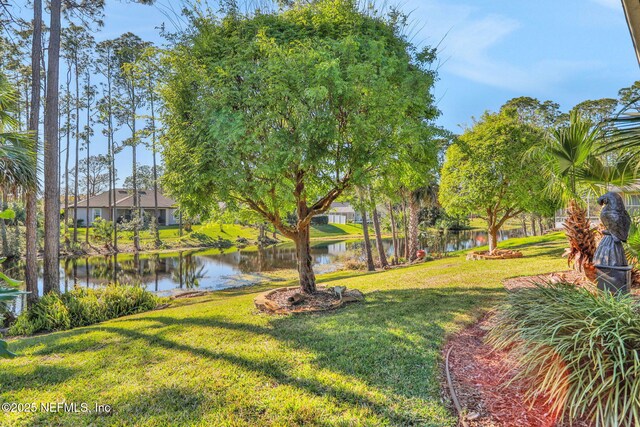 view of community featuring a yard and a water view