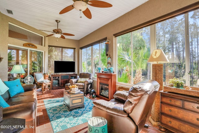 sunroom with visible vents and a glass covered fireplace