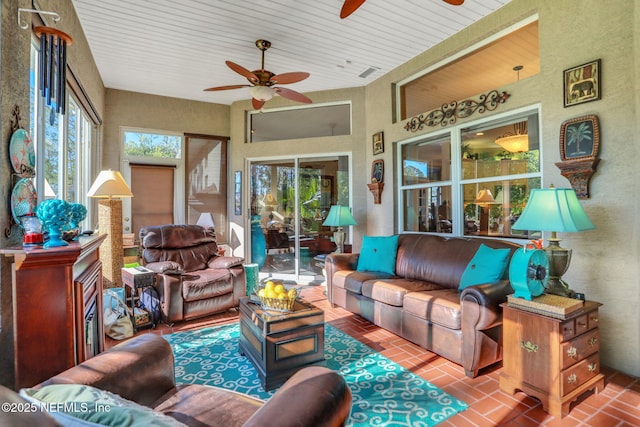 living room featuring brick floor and a ceiling fan