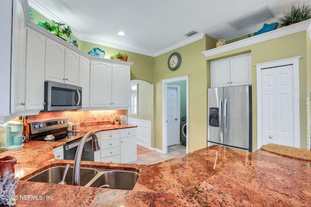 kitchen featuring a sink, stainless steel appliances, light stone counters, and white cabinets