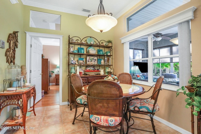 dining area with visible vents, a ceiling fan, crown molding, light tile patterned floors, and baseboards